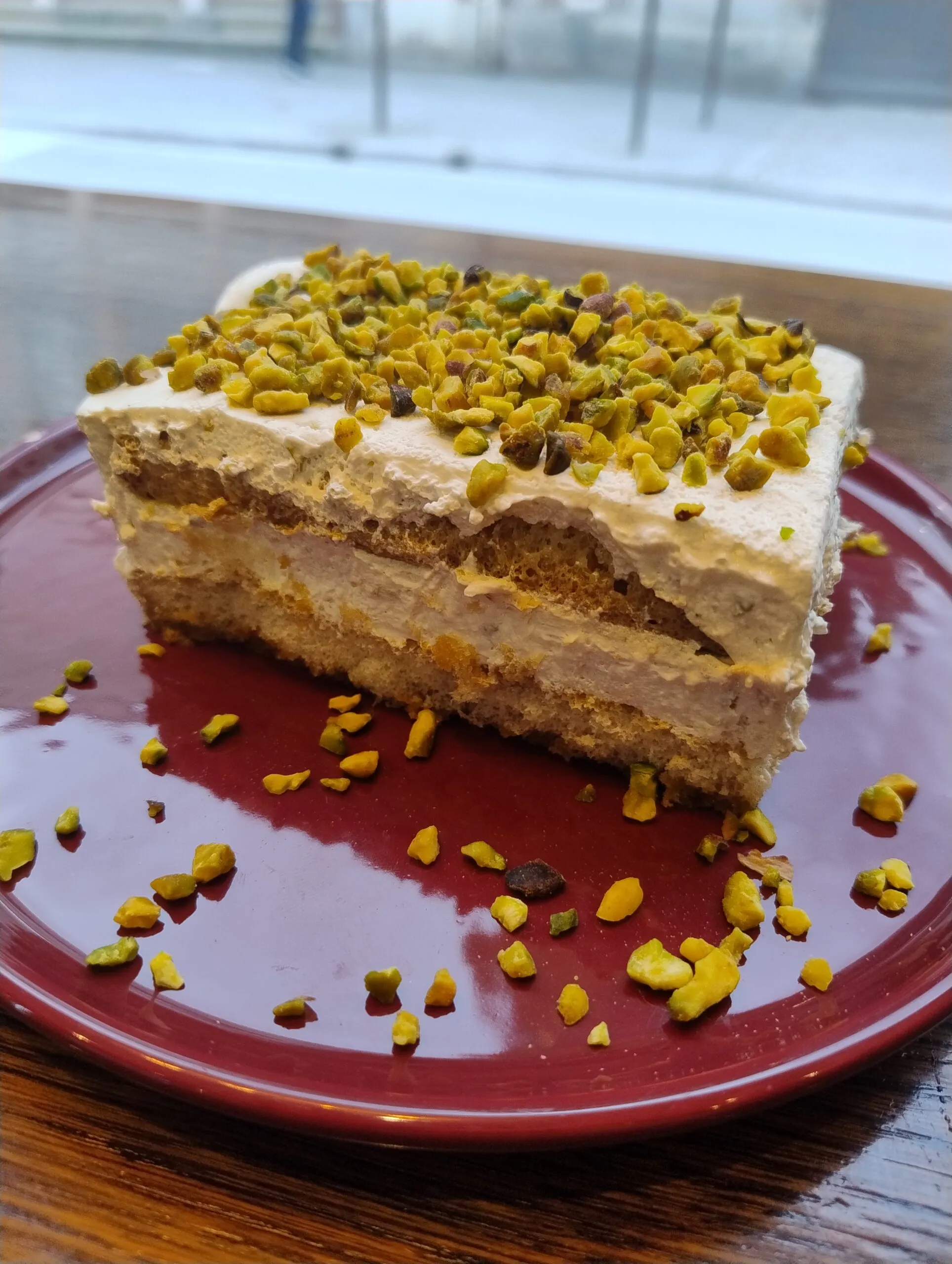 Part de tiramisù à la pistache, couches de biscuits et de crème
